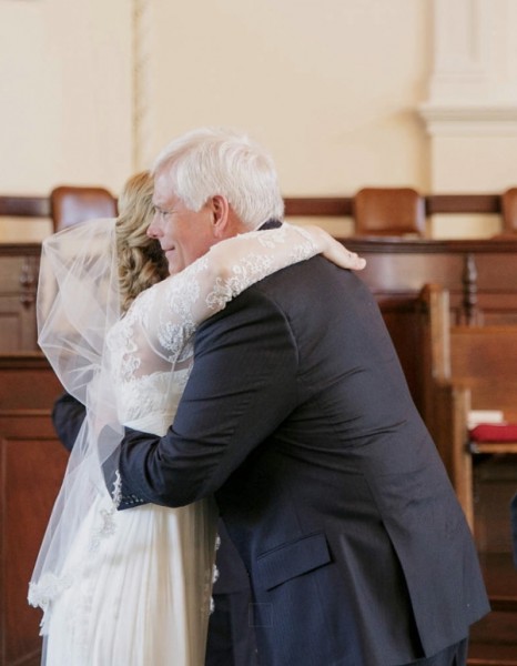 Wedding Kara hugging Bil at altar